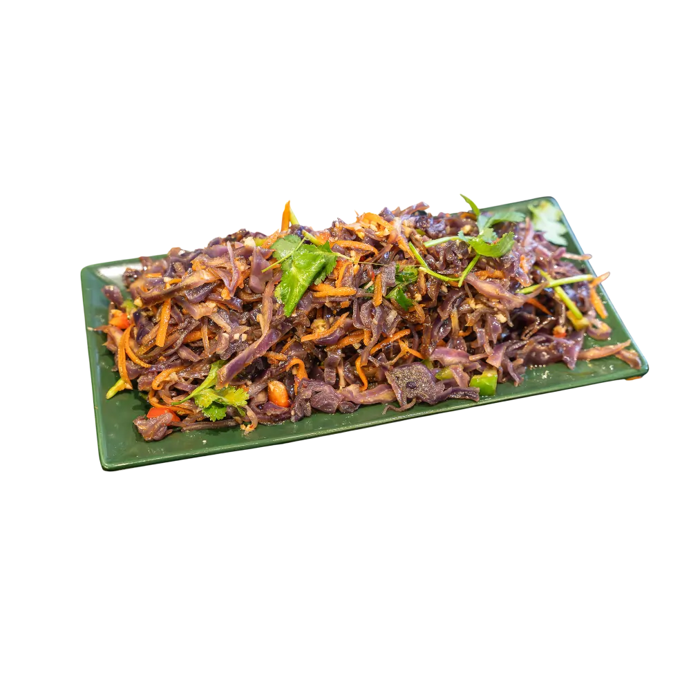 Red cabbage and carrot salad with herbs and peanuts on a green plate 