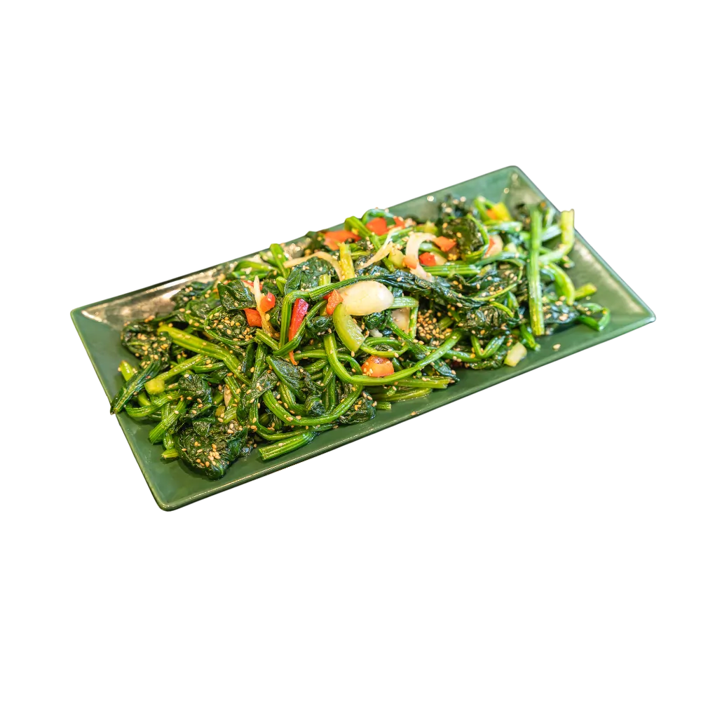 Seasoned spinach salad with sesame seeds, peppers and garlic on a green plate
