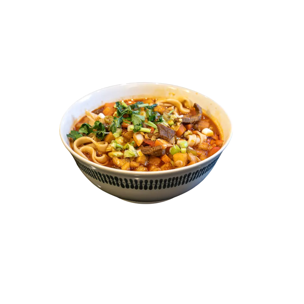 Ygrä-style Uyghur noodle soup with beef, vegetables and fresh herbs in a deep bowl